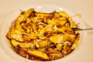 potatoes cut and cooked in the oven with onion and cheese