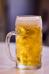 a pint of cold and steaming beer on a table