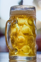 a pint of cold and steaming beer on a table