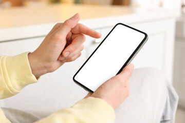 Woman using modern smartphone at home, closeup