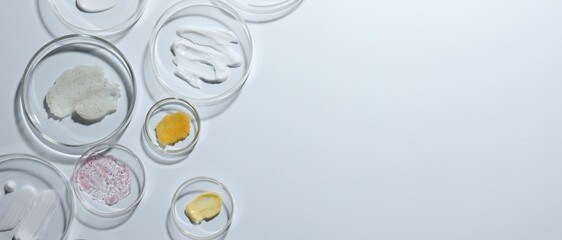 Different cosmetic products in Petri dishes on white background, flat lay. Space for text