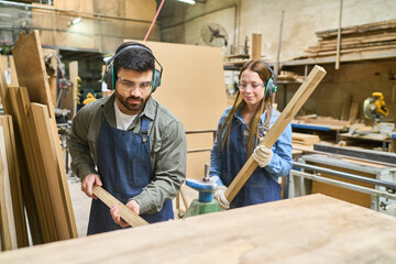 Young and older worker collaborating in a lumberyard setting