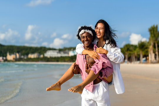 Beautiful diverse couple enjoying in good mood on the beach. Lifestyle love dating vacation concept