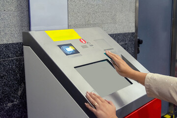 Woman using self service ticketing machine in subway station. Concept of inclusion, adapted public
