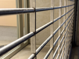 Close-up view of metal grate with horizontal bars in an industrial setting