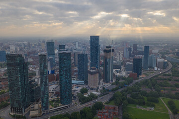 Fototapeta premium Aerial image of Manchester cityscape in the morning with sun-rays breaking through the clouds 