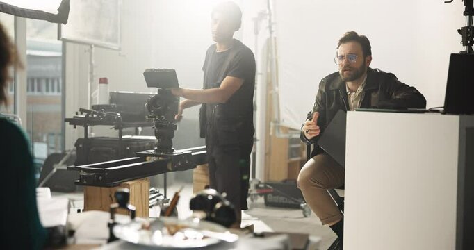 Conversation, film and media with director speaking to person on set for advertising instructions. Behind the scenes, explain and production with videographer man talking to actress for direction