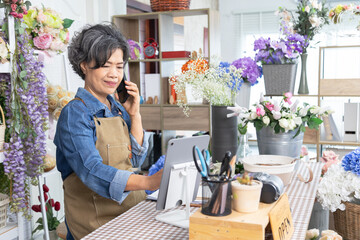 Senior, woman, florist small business owner, entrepreneur happily opening flower shop, showing...