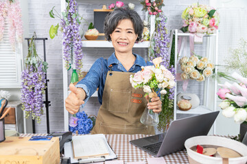 Asian senior woman, florist, small business, owner, entrepreneur manage store accounting with...