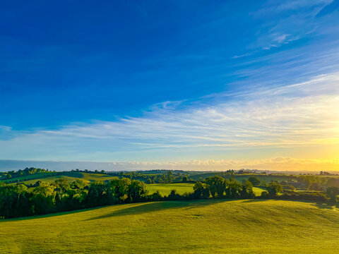 Golden hour light over green fields and rolling hills in County Meath, Ireland