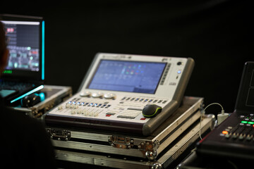 Fototapeta premium Professional lighting control console with touchscreen interface and faders, used for live stage event management and show lighting synchronization. Indoors setup.