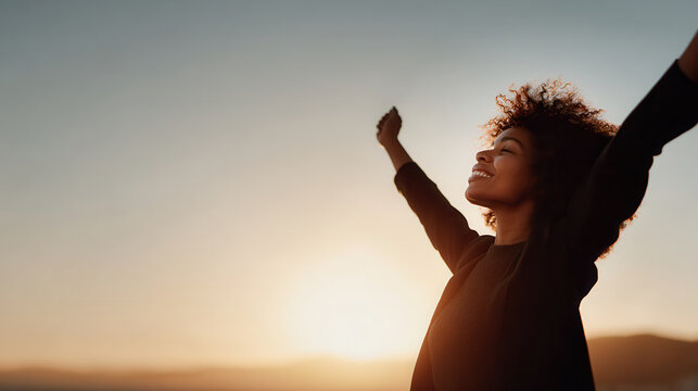jubilant portrait of person celebrating milestone with stunning sunset in background