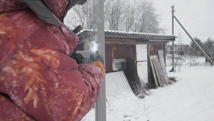 A beautiful snowy landscape showcases a person skillfully working with various tools near a rustic...
