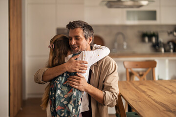 Loving Father Embraces Daughter With Backpack in Modern Kitchen Setting