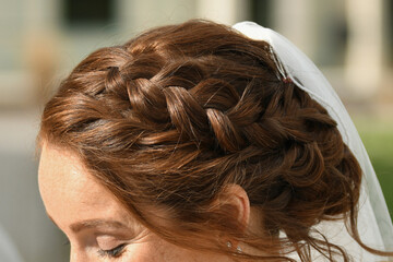 Red hair of the bride braided