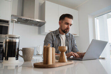  Man Working from Home with Coffee and Snacks in Modern Kitchen