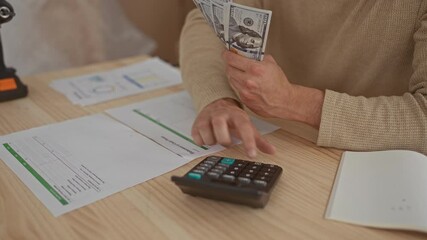 Man hands counting at home desk display young hispanic boxes containing cash near calculator and bills. - Powered by Adobe