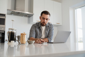  Man Working from Home with Coffee and Snacks in Modern Kitchen