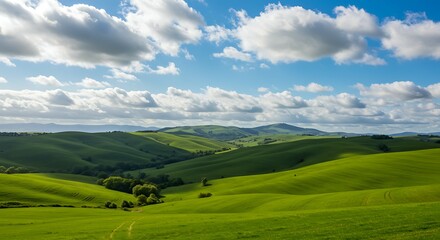 Obraz premium Rolling green hills under a beautiful blue cloudy sky