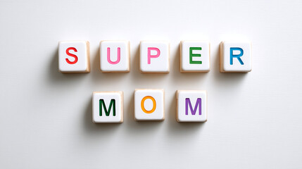 Obraz premium Celebrate motherhood with colorful letters spelling Super Mom in an artistic arrangement on a bright backdrop