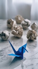 Blue Origami Crane and Crumpled Paper Balls on Marble Surface