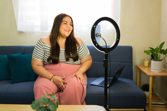 Plus-size vlogger creating social media content at home - Powered by Adobe