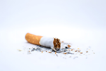 Broken cigarette on white surface with ashes.
Crushed cigarette with scattered tobacco and ash, symbolizing smoking cessation or health awareness campaign.