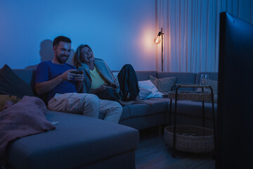 Naklejka premium Couple Playing Video Games Together in Cozy Living Room at Night