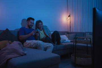 Couple Playing Video Games Together in Cozy Living Room at Night