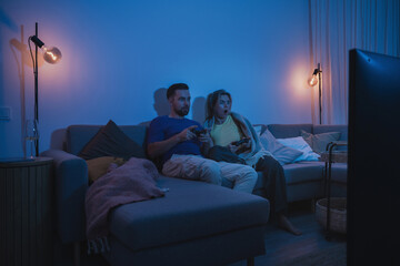 Couple Playing Video Games Together in Cozy Living Room at Night