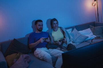 Couple Playing Video Games Together in Cozy Living Room at Night