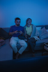 Couple Playing Video Games Together in Cozy Living Room at Night