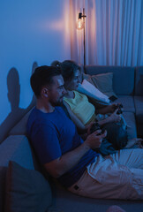 Couple Playing Video Games Together in Cozy Living Room at Night