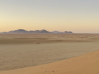 Vast Desert Landscape at Sunset Sand Dunes and Distant Mountains
