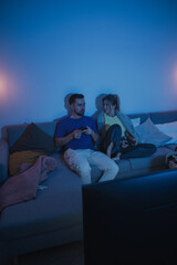 Couple Playing Video Games Together in Cozy Living Room at Night