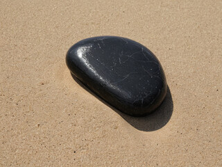 Smooth Black Stone on Sandy Beach Nature's Simple Beauty