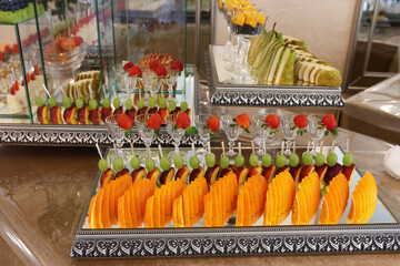 Fruit and cakes on a festive buffet table.