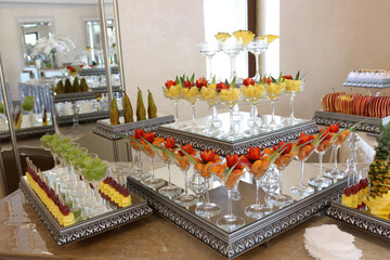Fruit and cakes on a festive buffet table.