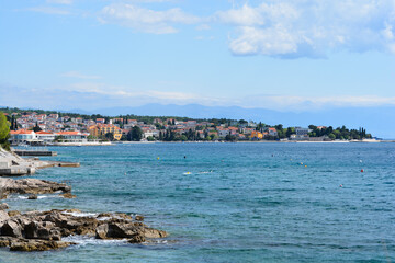 Fototapeta premium A panoramic view of the coastal town of Selce, Croatia, showing its waterfront buildings, the calm blue sea with buoys, and rocky shore