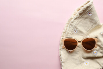 Sunglasses on a plain background. Summer, chamomile
