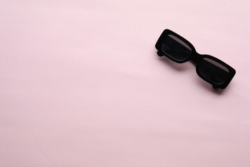 Sunglasses on a plain background. Summer, chamomile