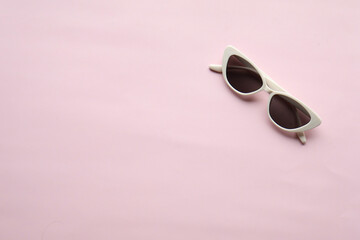 Sunglasses on a plain background. Summer, chamomile