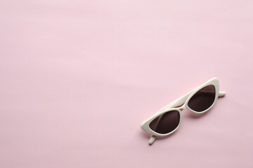 Sunglasses on a plain background. Summer, chamomile