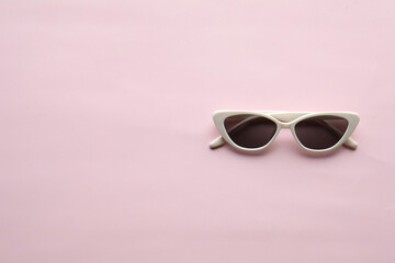 Sunglasses on a plain background. Summer, chamomile
