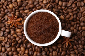 Cup with instant coffee powder and star anise on beans, top view