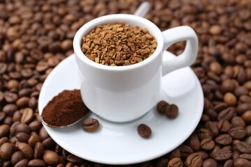 Cup with granulated instant coffee and powder on beans, closeup
