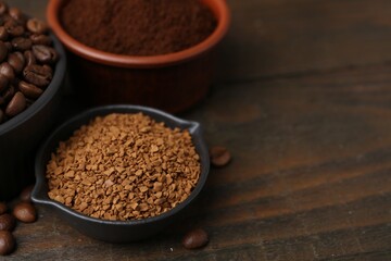 Different types of instant coffee and beans in bowls on wooden table, closeup. Space for text