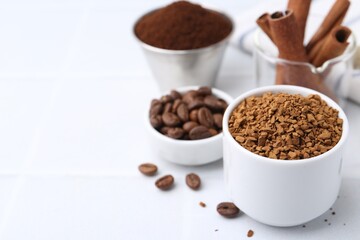 Granulated instant coffee and beans on light table, selective focus. Space for text