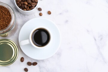 Aromatic hot drink, instant coffee and beans on white marble table, flat lay. Space for text