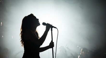 Female singer silhouette performing live on stage with microphone